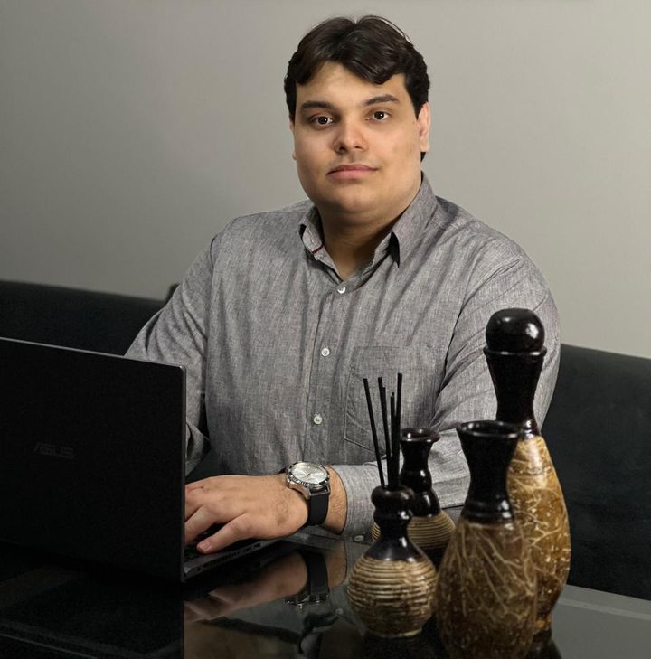 Vitor Arguello em seu consultório, trabalhando ao computador